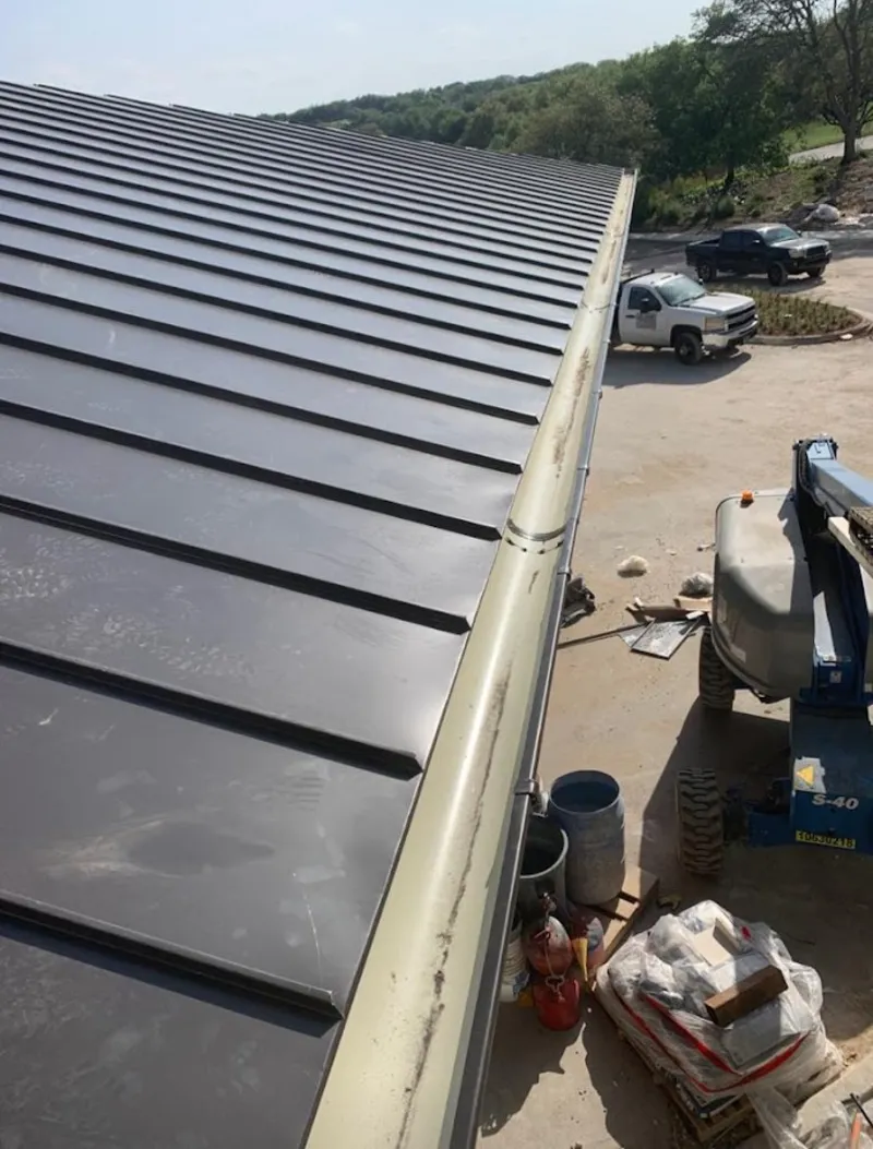 Standing seam panel and gutter detail on a metal roofing jobsite in Braddock